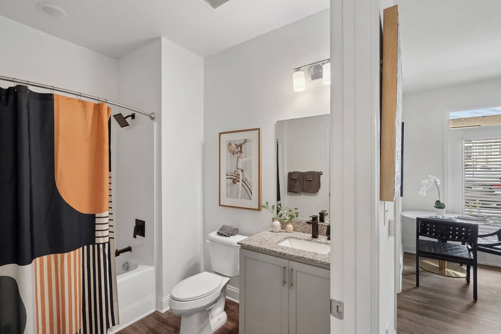 a bathroom with a shower and a toilet and a sink