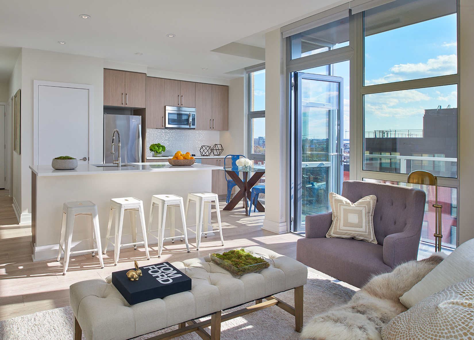 a living room with a couch and a kitchen with stools