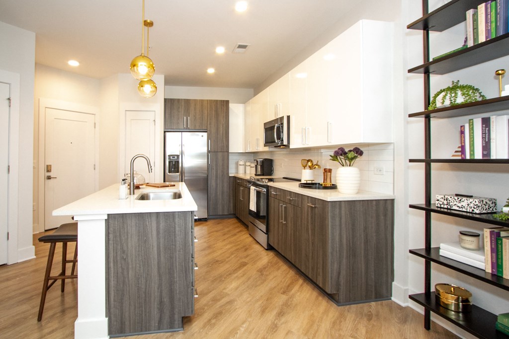 a kitchen with a large island and a stainless steel refrigerator