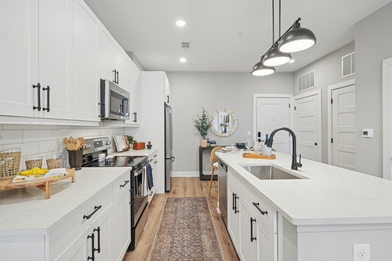 A modern kitchen with white cabinets and a central island.