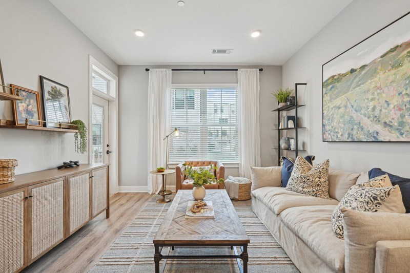 A living room with a large couch, a coffee table, and a painting on the wall.