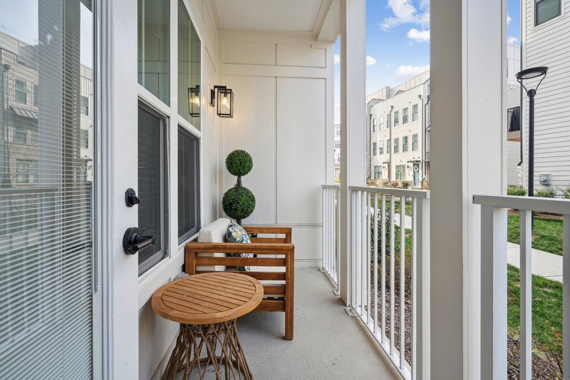 A balcony with a table and chairs is shown.