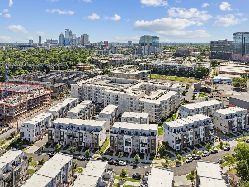 A cityscape with a mix of residential and commercial buildings under a clear sky.