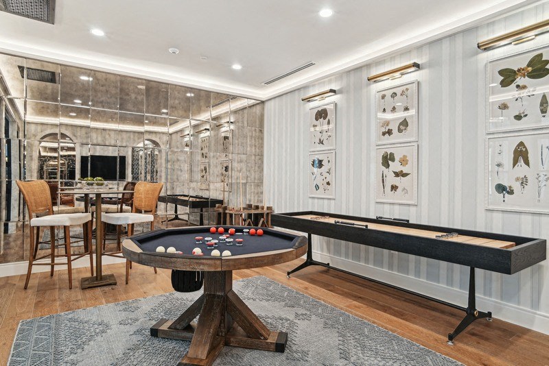 a game room with a shuffle board table and bumper pool