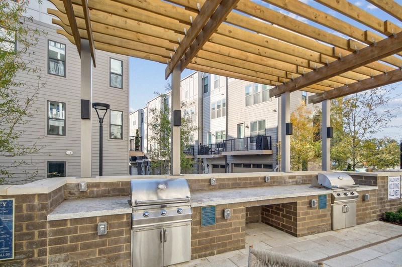 a large outdoor kitchen with a grill and a patio