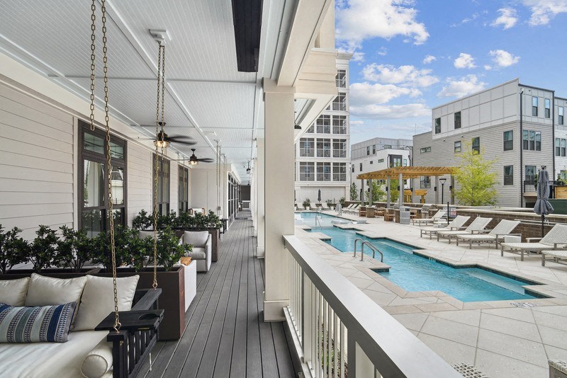 a pool and lounge area on the balcony of a building