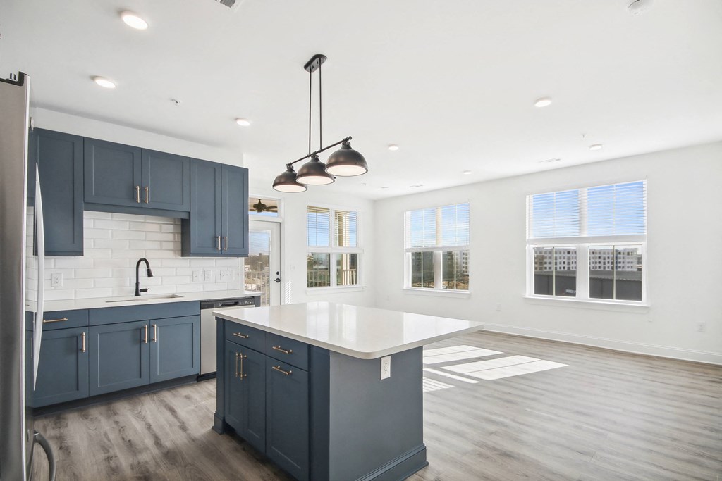 a white and blue kitchen with blue cabinets and a white counter top