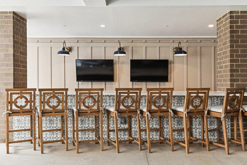 a long table with chairs in a room with televisions