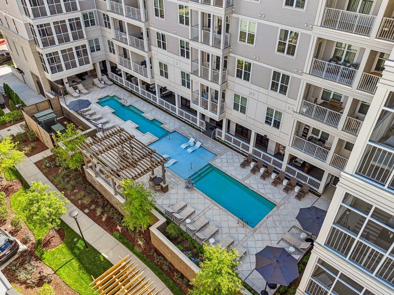 A large apartment complex with a pool and a patio area.