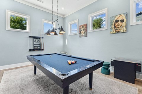 the pool table in the game room of a modern home