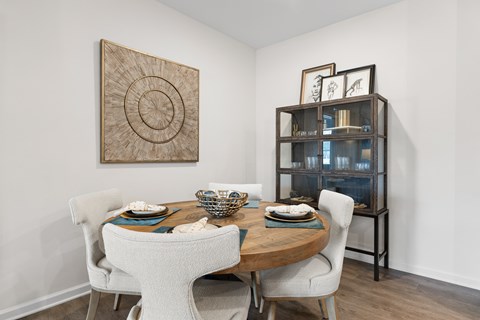 A dining room with a wooden table and chairs.