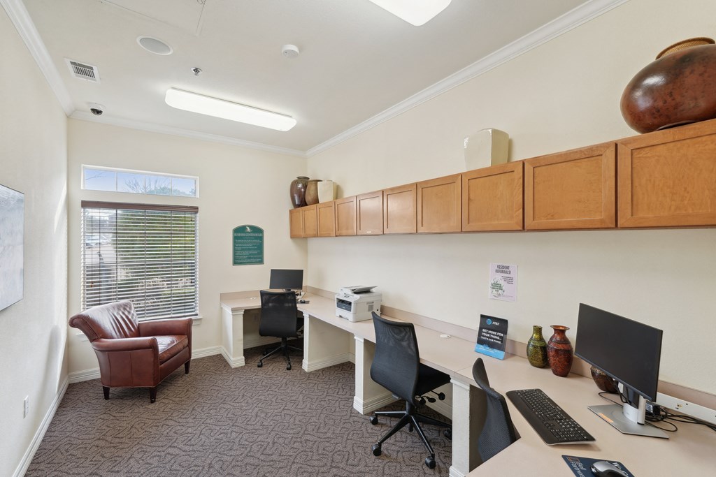 an office with two desks and computers and a chair