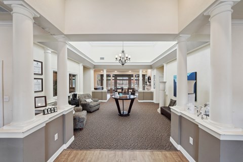 a large room with pillars and a table in the middle
