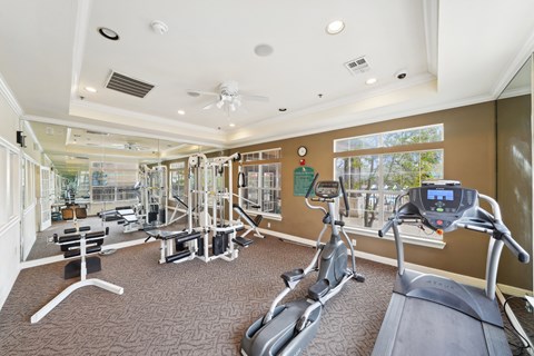 a gym with exercise machines and windows