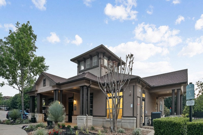 the front of a building with a clock on the side of it