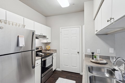 a kitchen with stainless steel appliances and white cabinets