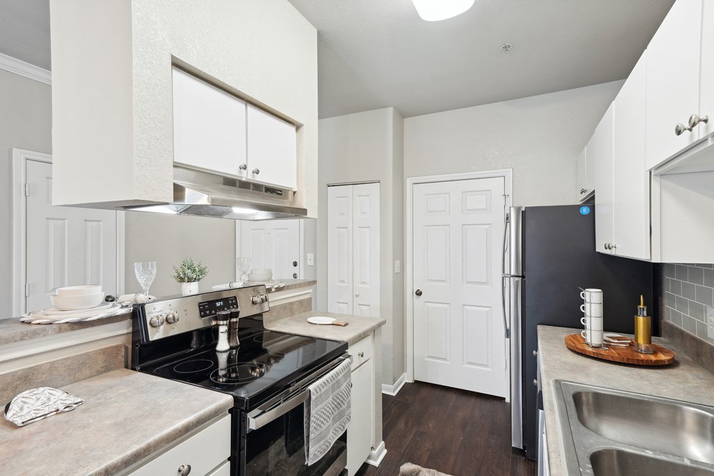 a kitchen with a stove and a refrigerator and a sink