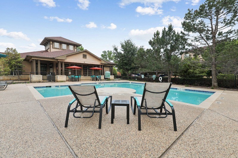 a patio with a pool and a table and chairs