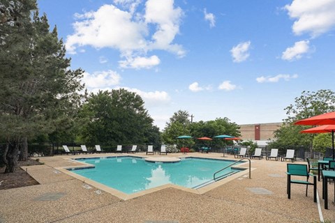 a pool with umbrellas and chairs around it at a hotel