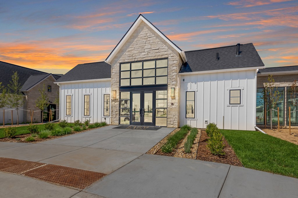 an exterior view of a building with a sunset in the background