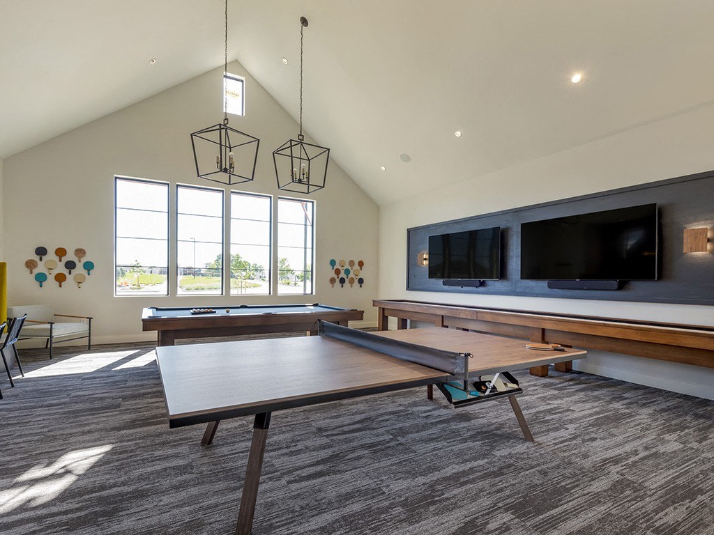 a game room with a ping pong table and a television