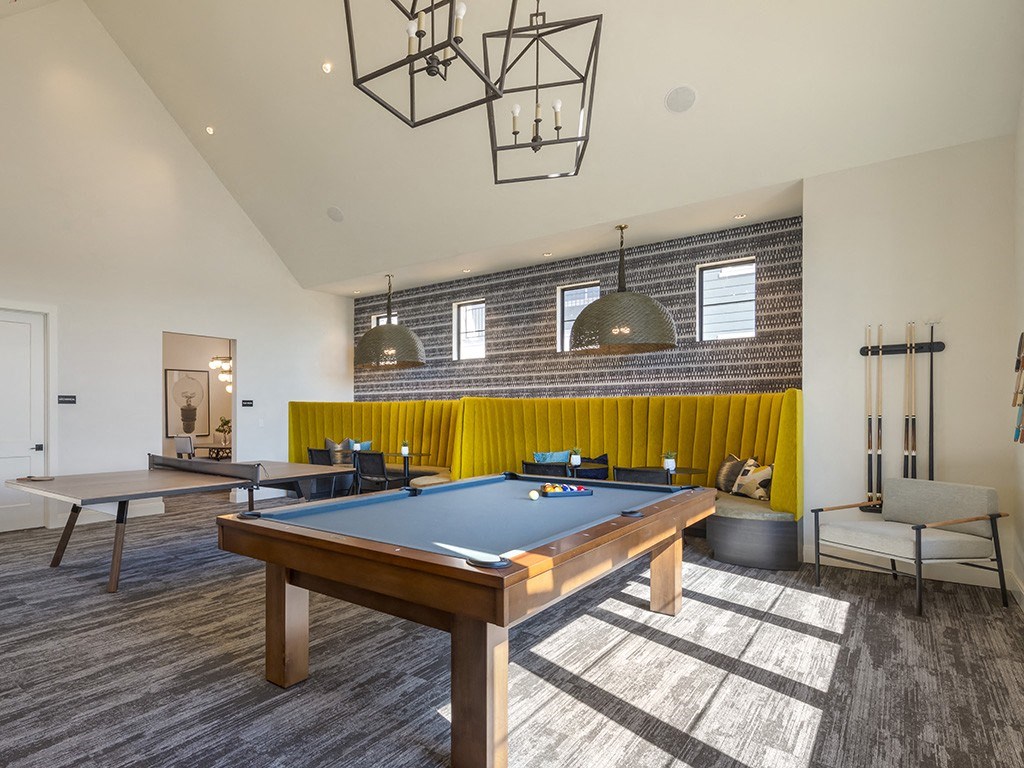 a community room with a pool table and ping pong tables