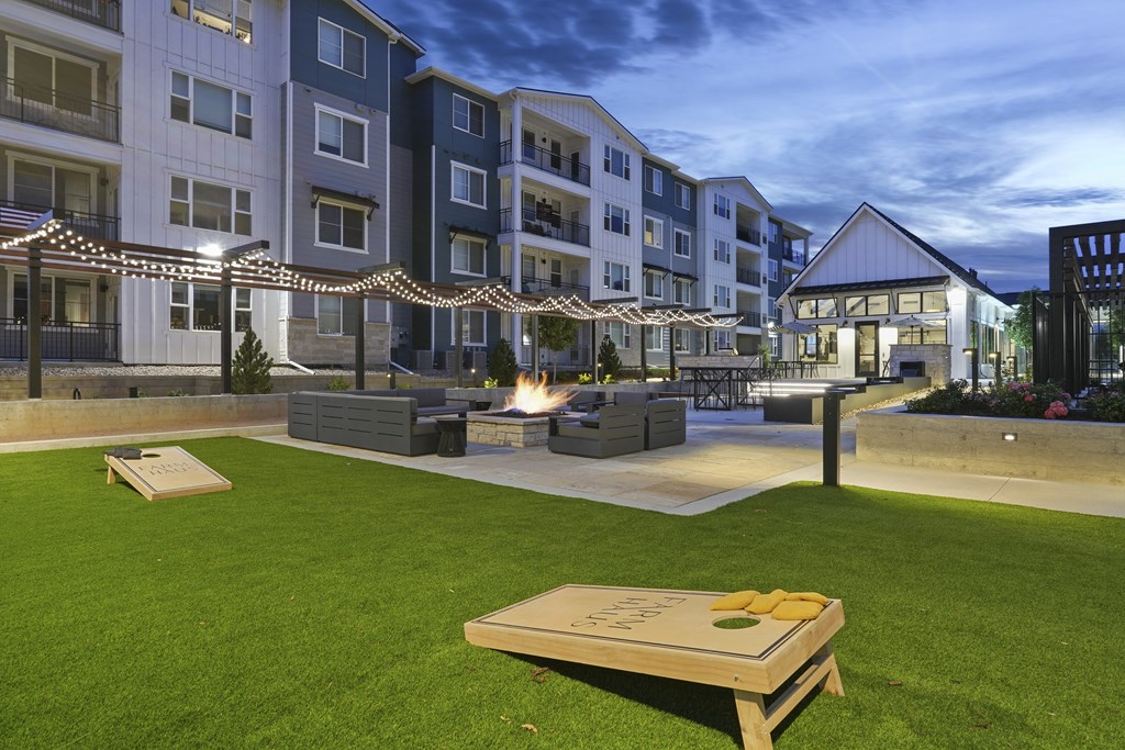 an exterior view of an apartment building with a fire pit