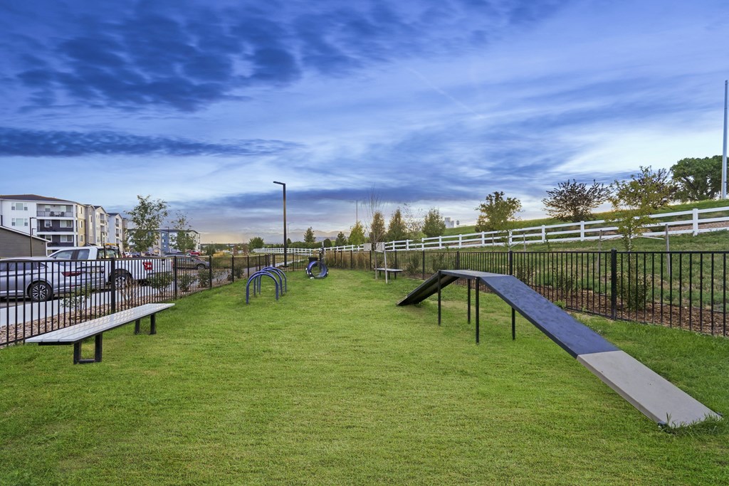 a park with benches and a grassy area and a fence