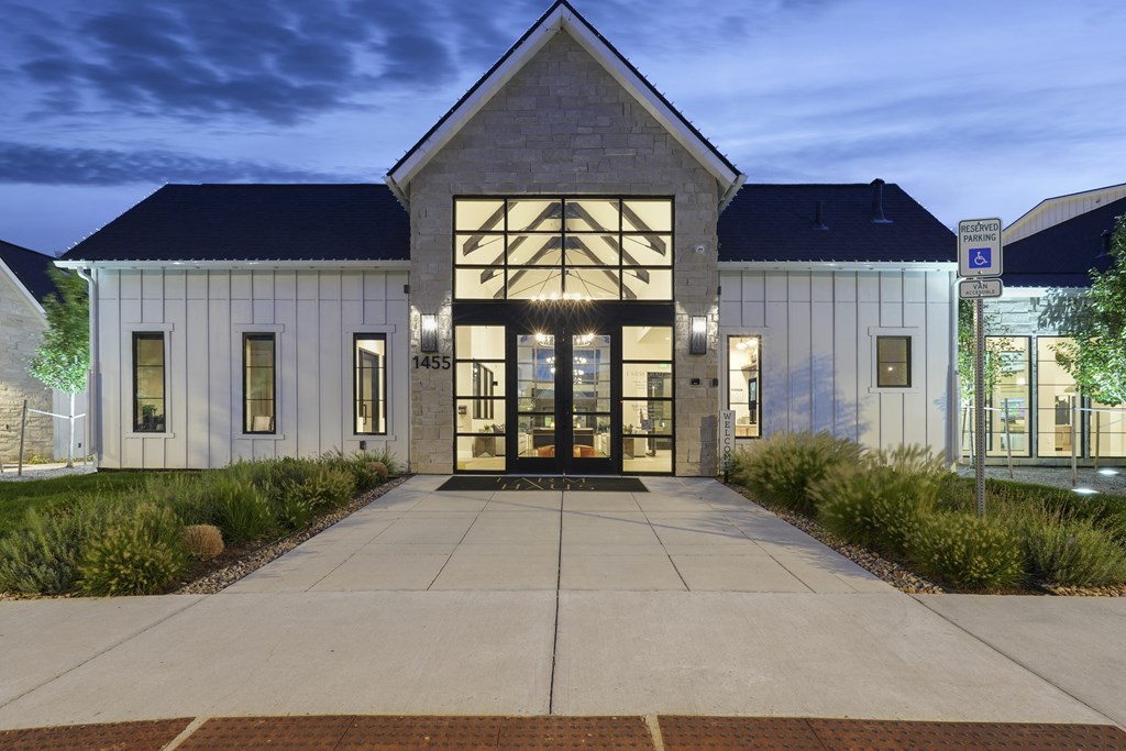 the front of a church with a sidewalk and a building with glass doors