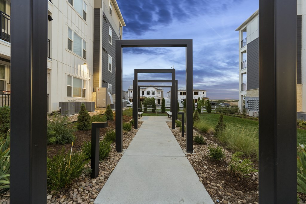 an open walkway between two apartment buildings with a view of the city
