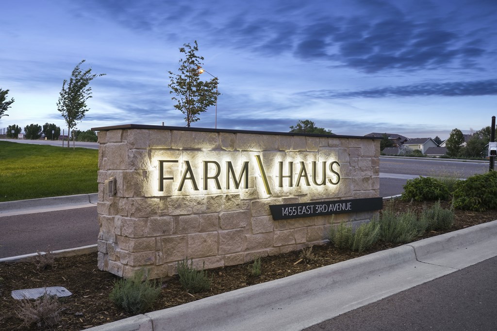 a stone sign that reads farmhaus on the side of a road