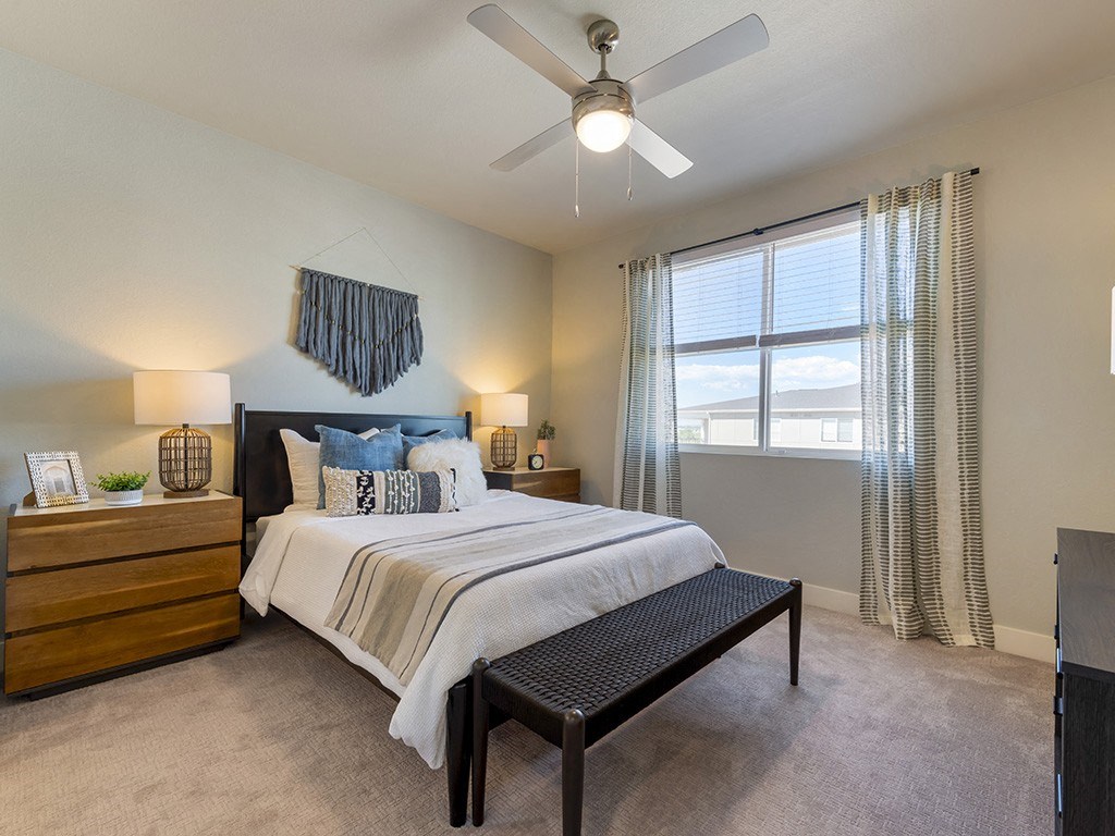A bedroom with a bed, nightstand, and window.