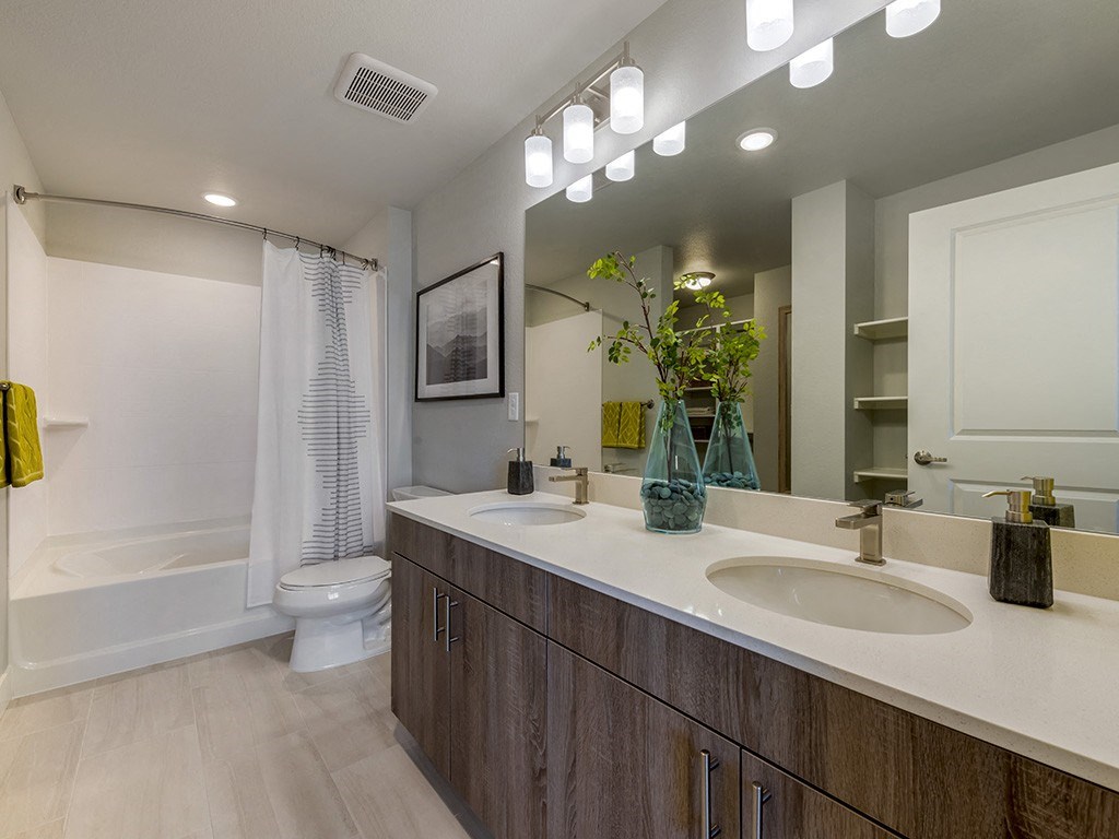 A bathroom with a white tub, sink, and toilet.