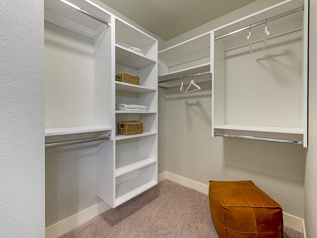 A white closet with a basket on the shelf.