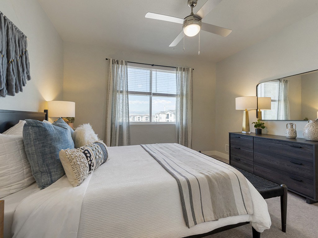 a bedroom with a large bed and a ceiling fan