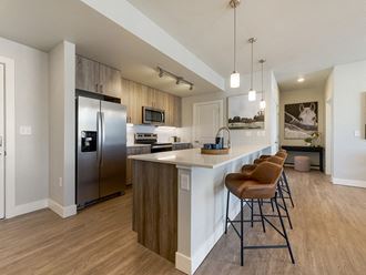a kitchen with stainless steel appliances and a bar with stools