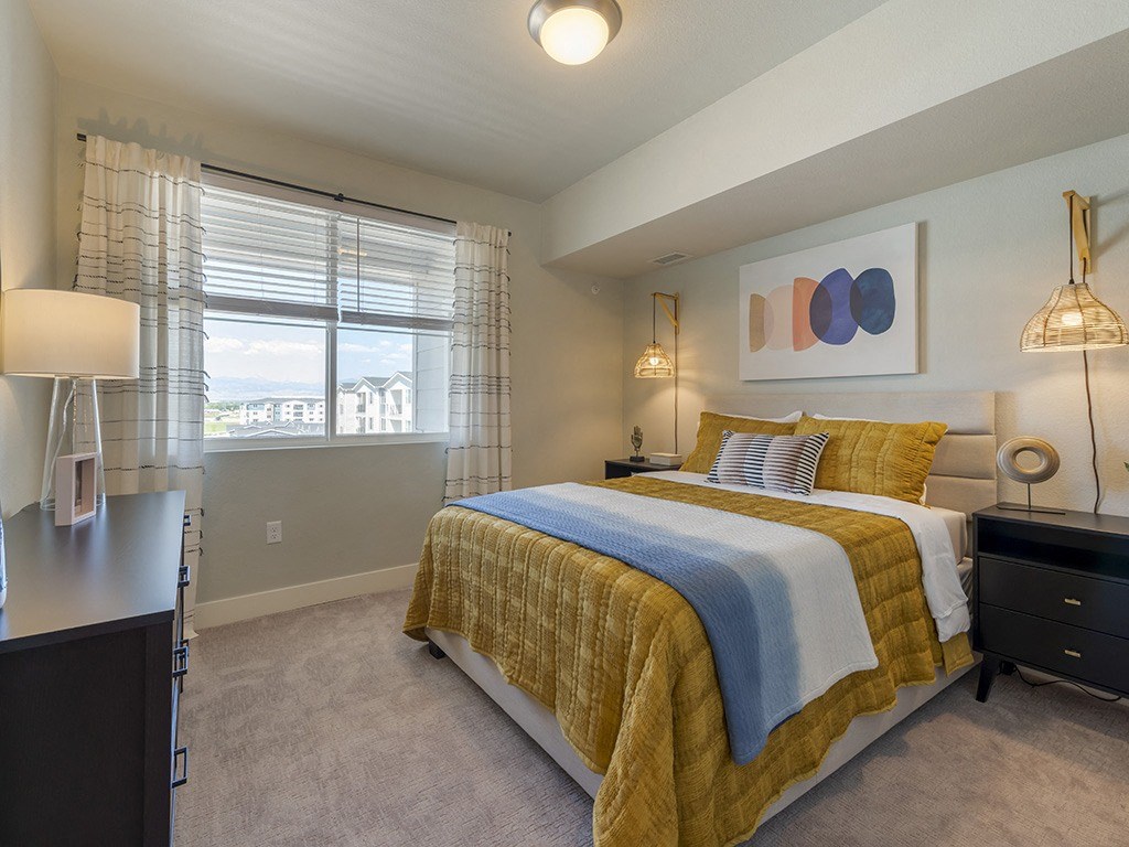 a bedroom with a bed and a window with blinds