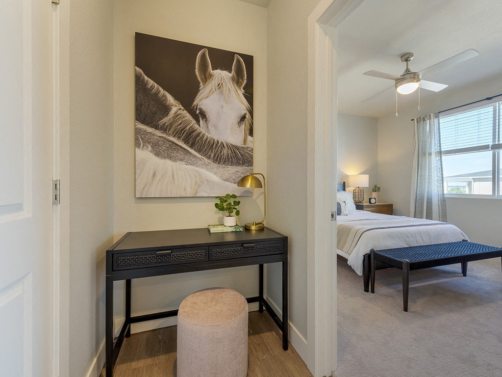 A bedroom with a large painting of a horse on the wall.