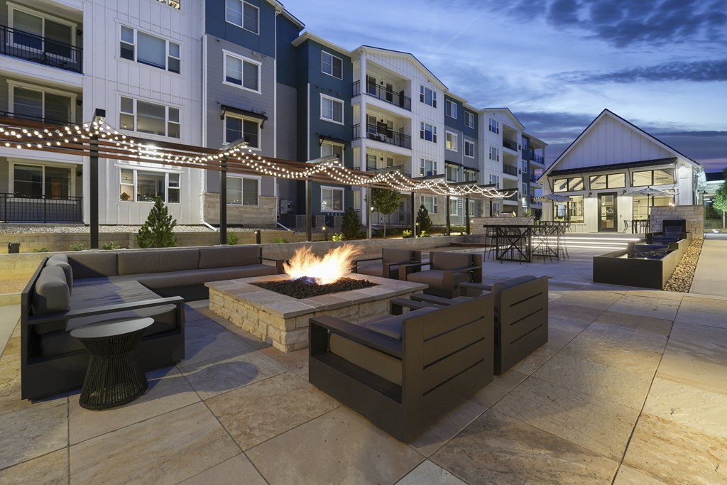 an outdoor patio with a fire pit at an apartment complex