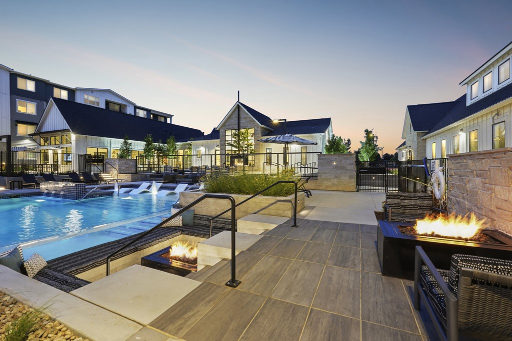 a swimming pool with a fire pit at night