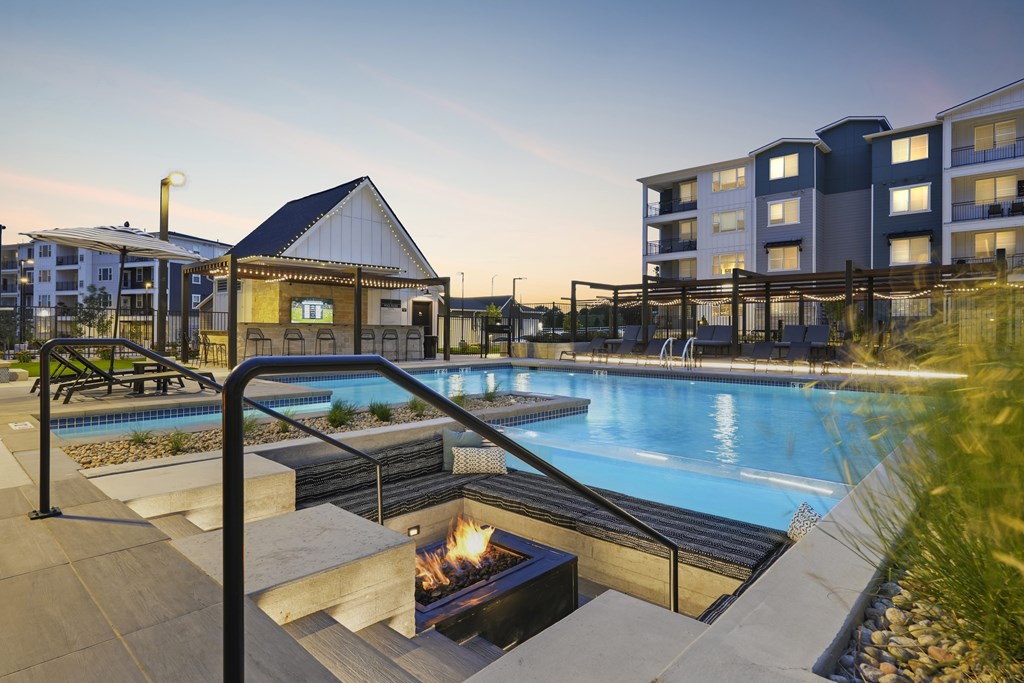 A pool with a fire pit in the middle of it.
