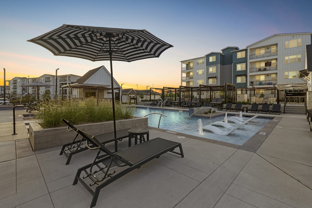 a pool with chairs and umbrellas next to a hotel pool