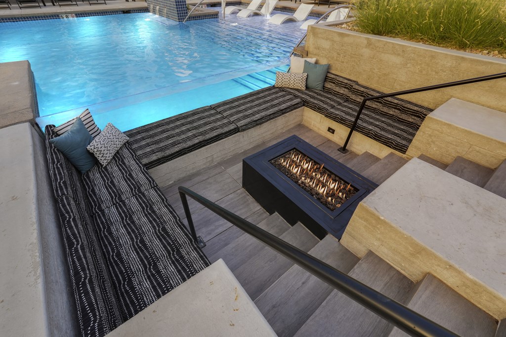 a swimming pool with a fire pit in the middle