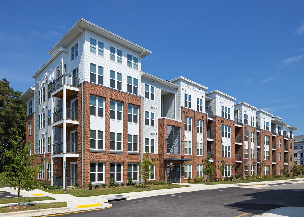 a row of brick and white apartment buildings on a sunny day