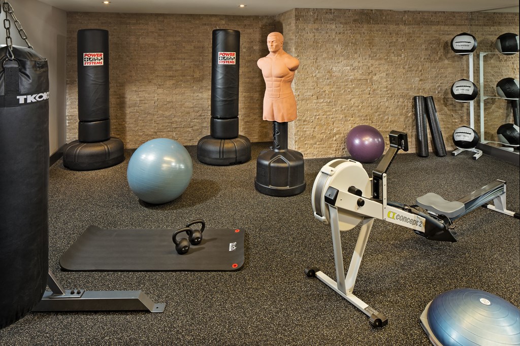 a large fitness room with weights a treadmill and other exercise equipment