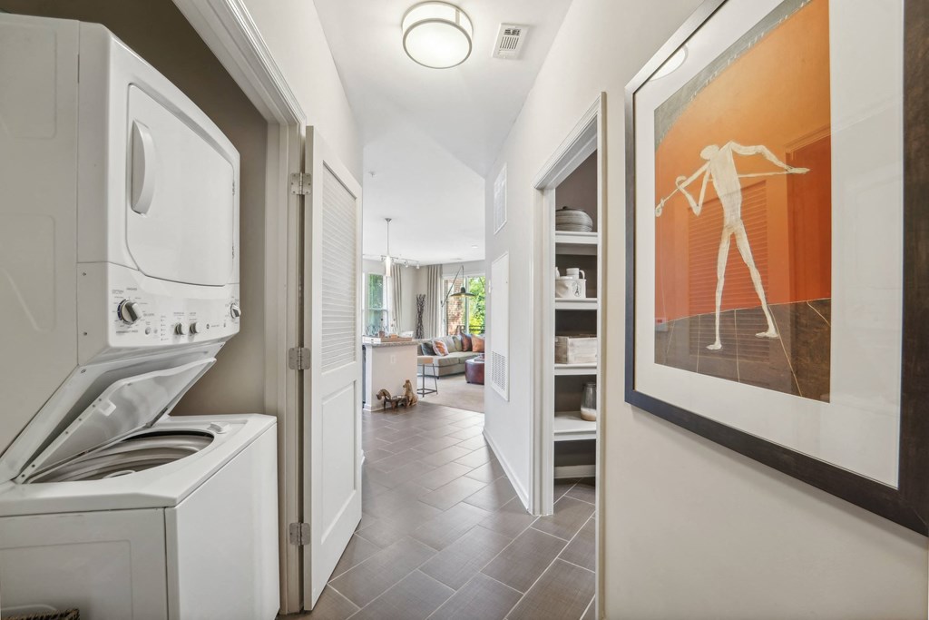 a laundry room with a washer and dryer and a hallway to a kitchen