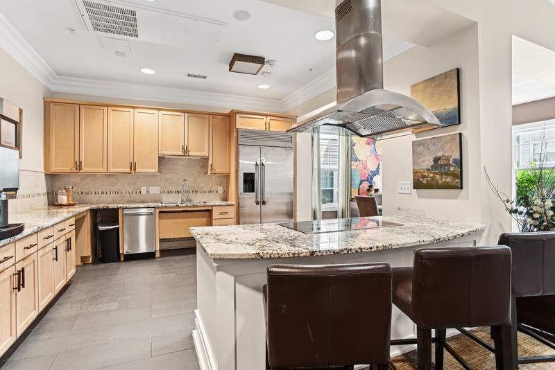 A kitchen with a marble countertop and a large island.