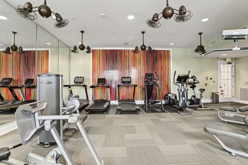 A gym with treadmills, elliptical machines, and other exercise equipment.