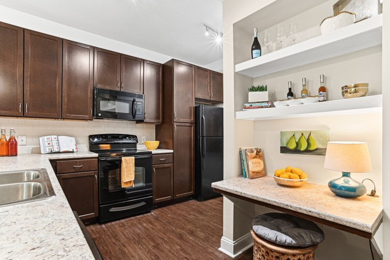 A kitchen with brown cabinets and a black oven.
