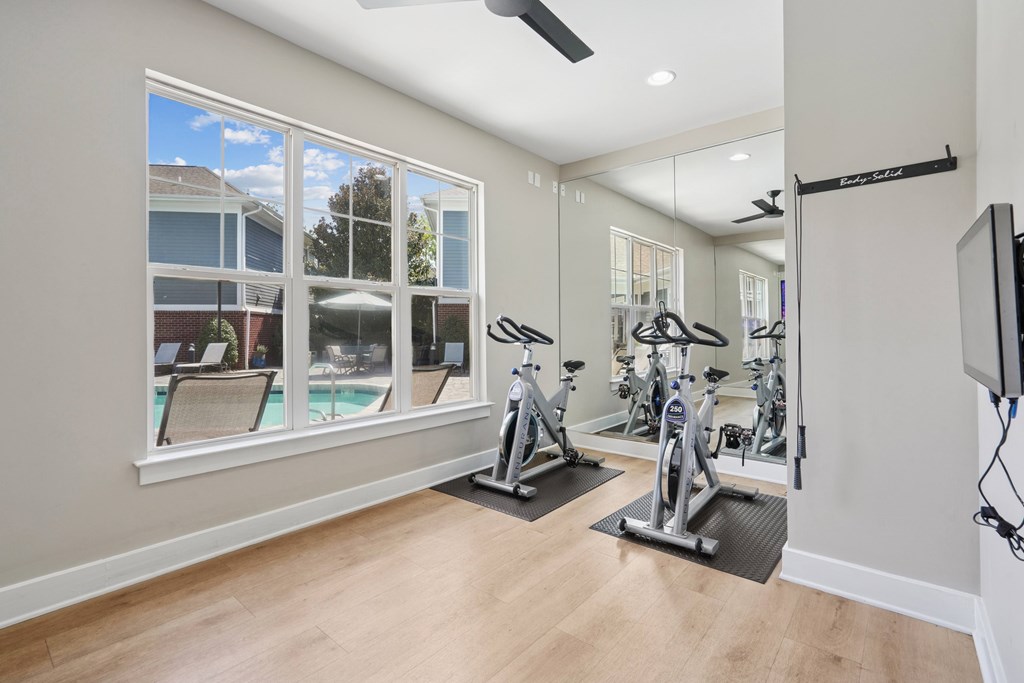 A spacious home gym with a television and exercise equipment.